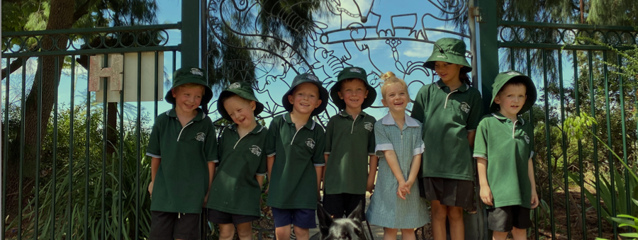 7 Kids at the front gate of Cara in green school uniform