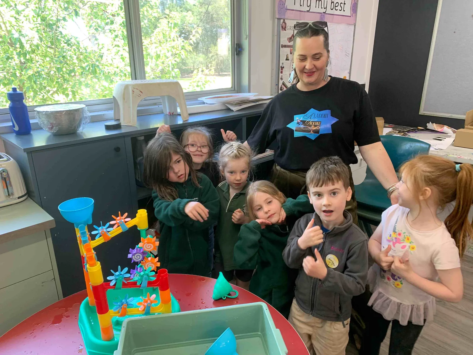 Foundation students gathered around a water-play table with their teacher